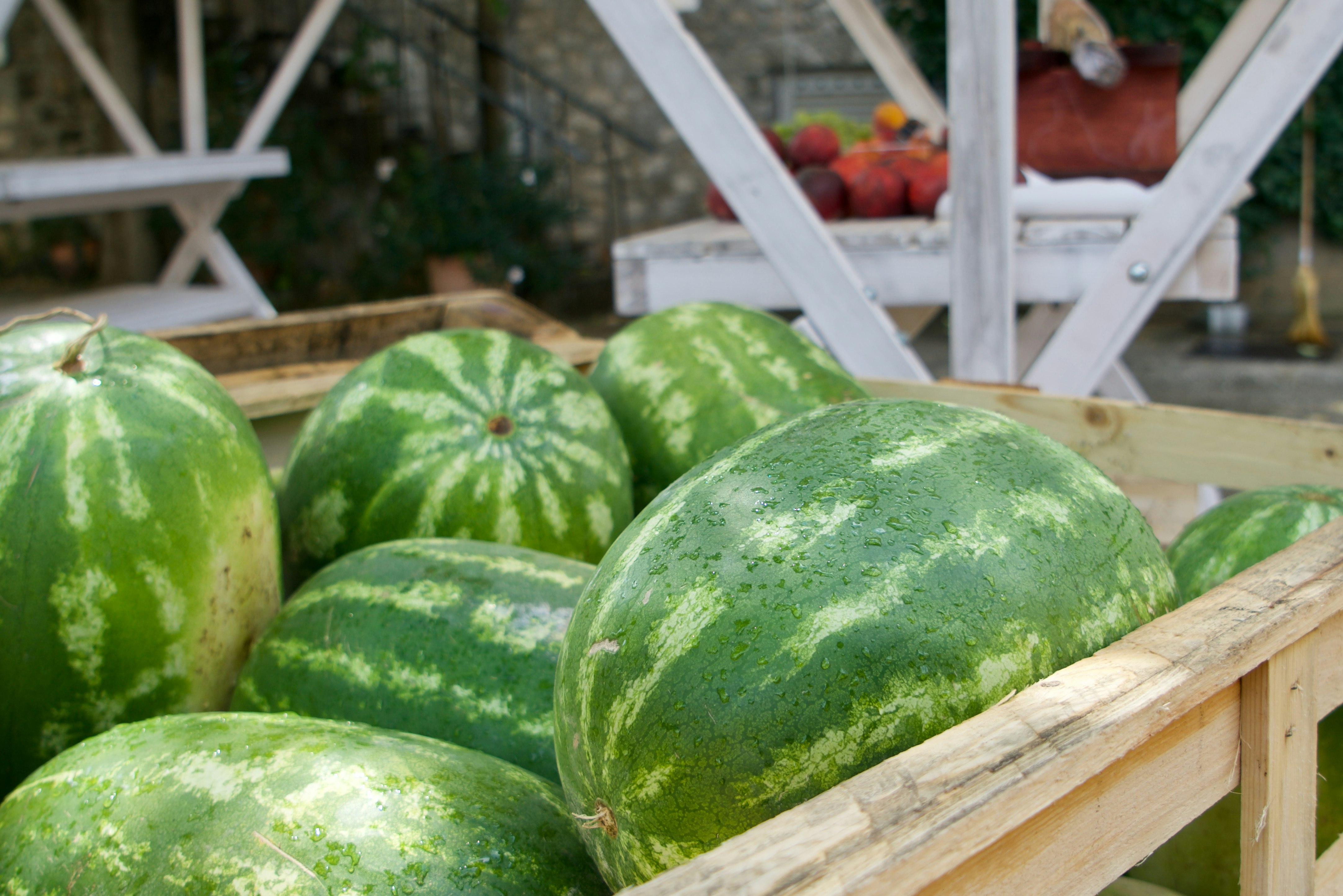 green watermelon on brown wooden crate